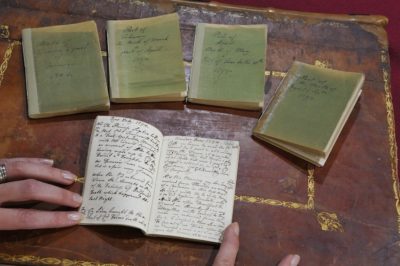 Five small diaries displayed on table